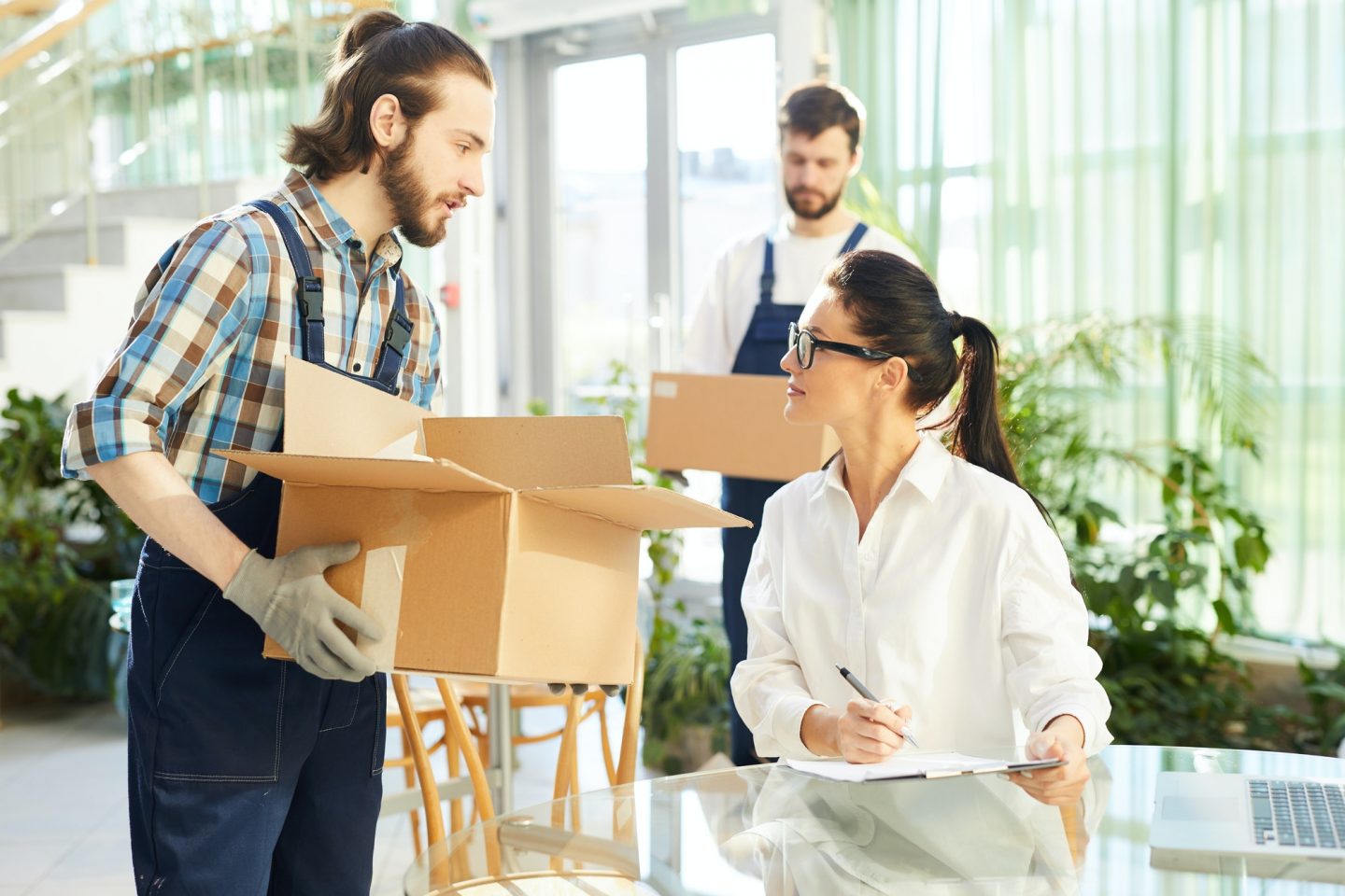 Female entrepreneur talking to movers in new restaurant